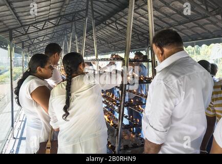 Kandy, Sri Lanka: 03/19/2019: Sanctuaire bouddhiste Sri Dalada Maligawa effrayé de la relique de Budda. Bougies d'éclairage Worhippers. Banque D'Images