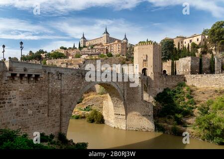 Pont Gate, Alcantara Bridge, Puente del Alcantara, au-dessus de la rivière Tajo, avec Alcazar de Toledo, Tolède, Castille-la Manche, Espagne Banque D'Images