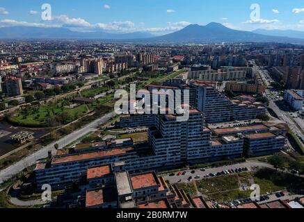 Vue sur les voiles dans le quartier de Scampia à la périphérie de Naples. La banlieue napolitaine du nord de Scampia est connue pour ses guerres de drogue, les batailles de clan entre les factions rivales mafias (Camorra) et a été présentée dans le film Gomorrah. En arrière-plan le volcan Vésuve. 21/02/2020, Naples, Italie Banque D'Images