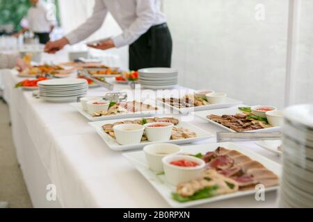 Une table de banquet sert des plats avec des viandes assorties et des sauces Banque D'Images