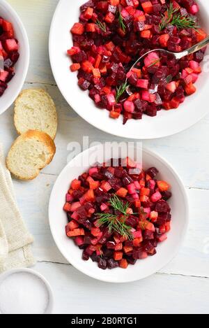 Bol à salade sur fond de bois clair. Salade de betterave de désintoxication en bonne santé, la pomme de terre, de carottes, de cornichons. Végétalien végétarien aliments biologiques ou naturels Banque D'Images