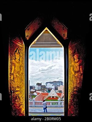 Bangkok, Thaïlande: Vue à travers une fenêtre à Wat Traimit (le Bouddha d'or), les murs de couleur dorée brillent à côté du mur noir Banque D'Images