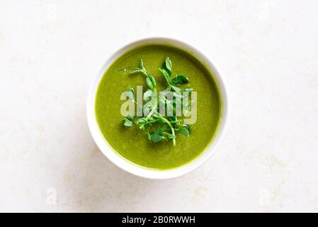 Soupe saine de crème de pois verts de brocoli dans un bol sur fond de pierre claire avec espace texte libre. Régime alimentaire Detox concept de nourriture. Vue sur le dessus, plat Banque D'Images