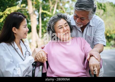 Infirmière regardant un patient âgé en fauteuil roulant. Médecin parlant à des personnes âgées handicapées Banque D'Images