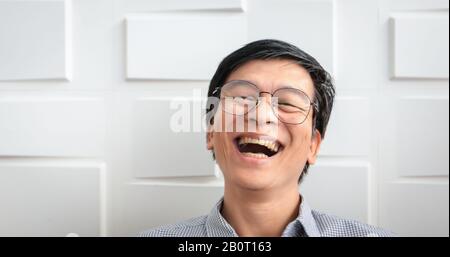 L'homme asiatique principal sourit et rit heureux Banque D'Images