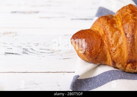 Croissant de rosy français sur serviette claire sur fond blanc. Concept de boulangerie. Banque D'Images