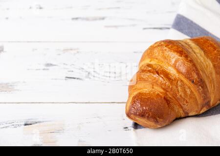 Croissant de rosy français sur serviette claire sur fond blanc. Concept de boulangerie. Banque D'Images