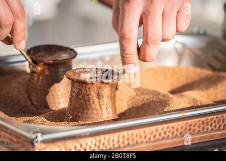 Préparation du café turc dans le cezve dans le sable Banque D'Images
