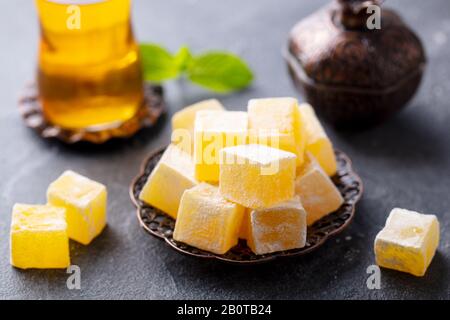 Le plaisir turc sur une plaque de cuivre avec un verre de thé. Fond en pierre grise. Gros plan. Banque D'Images