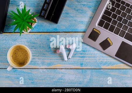 Fichier de sauvegarde chaque photographe d'utiliser le stockage externe disque dur et lecteur USB3.0 de mémoire cartes SD sur clavier d'ordinateur portable avec verres et café Banque D'Images