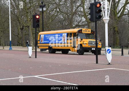 Un bus scolaire yellwo avec un message post-anniversaire pour le duc de York, de l'avocat américain Gloria Allred, en conduisant le long du centre commercial vers Buckingham Palace, Londres. Mme Allred, qui représente cinq des victimes de Jeffrey Epstein, a été critique envers le duc pour ne pas parler avec le FBI de son ancien ami Epstein. Banque D'Images