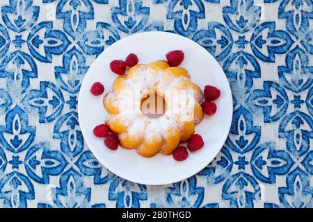 Gâteau de bundle au citron et à la vanille avec framboise sur fond bleu. Vue de dessus. Gros plan. Banque D'Images