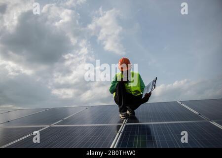 Un technicien vérifie l'entretien des panneaux de cellules solaires. Banque D'Images