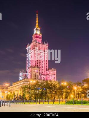 Illuminé la nuit, le Palais de la Culture et de la Science (1955) est un gratte-ciel de conception soviétique dans le centre de Varsovie, en Pologne. Banque D'Images