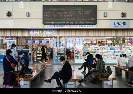 Daegu, Corée Du Sud. 21 février 2020. Les passagers attendent à une gare de Daegu, en Corée du Sud, sous un panneau indiquant les précautions à prendre pour éviter le coronavirus le 21 février 2020. Photo de Thomas Maresca/UPI crédit: UPI/Alay Live News Banque D'Images