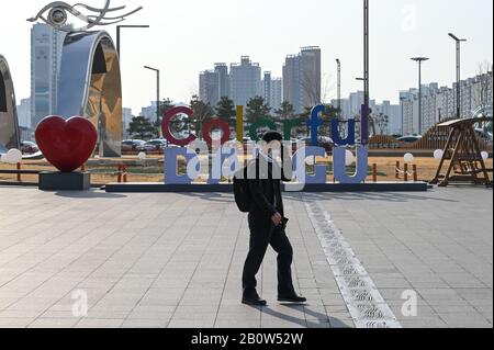 Daegu, Corée Du Sud. 21 février 2020. Un homme portant un masque de visage marche devant un panneau accueillant les visiteurs à Daegu à Daegu, Corée du Sud, le vendredi 21 février 2020. La majorité des cas de COVID-19 dans le pays ont été tracés à cette ville du sud-est. Photo de Thomas Maresca/UPI crédit: UPI/Alay Live News Banque D'Images