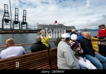 Drapeau écossais à l'arc du bateau à vapeur de Paddle Waverley avec le bateau à cunard la Reine Elizabeth au loin à Greenock sur le Clyde Banque D'Images