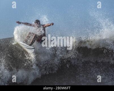 Un surfeur fait de grandes vagues décalées par la tempête tropicale Dorian alors que la tempête approche de Charleston Caroline du Sud. Banque D'Images