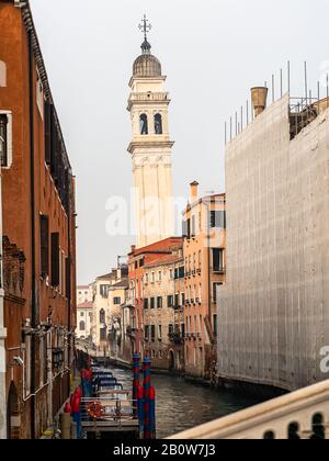 Canal avec bateaux à Venise (Italie) en hiver, clocher penchant de San Giorgio dei Greci Banque D'Images