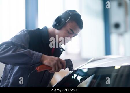 Pare-brise de voiture de fixation Workman en atelier Banque D'Images