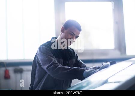 Pare-brise de voiture de fixation Workman en atelier Banque D'Images