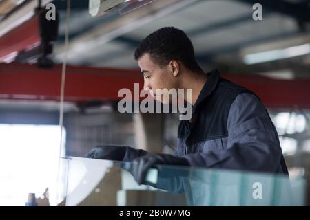 Pare-brise de voiture de fixation Workman en atelier Banque D'Images