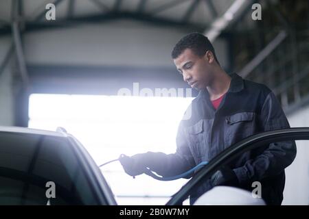 Pare-brise de voiture de fixation Workman en atelier Banque D'Images