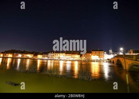 Bewdley, Royaume-Uni. 20 février 2020. Météo au Royaume-Uni : des niveaux de rivières sans précédent à Bewdley, Worcestershire, appellent à des services d'urgence locaux à travailler ensemble pour assurer la sécurité des entreprises et des résidents de la ville. Le haut d'un banc de bord de rivière peut être vu en jutisant hors de l'eau dans le bas à gauche de l'image que les lumières de nuit de rue le long de Riverside Sud, derrière les barrières d'inondation, reflètent dans les eaux gonflées de la rivière Severn. Crédit: Lee Hudson Banque D'Images