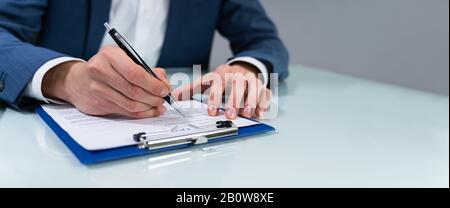Close-up of a person's Hand Signing Contract Banque D'Images