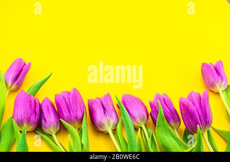 Bouquet de tulipes roses sur fond jaune avec espace de copie. Composition pour carte de vœux, mariage, mère, Valentin, femme, anniversaire, accouchement. Banque D'Images