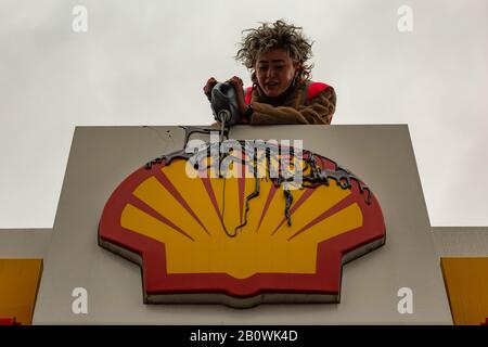 Cambridge, Royaume-Uni. 21 février 2020. Un activiste de extinction Rebellion verse du liquide noir sur le logo Shell dans une station-service de Newnham Road, Cambridge, pour protester symboliquement contre l'extraction de combustibles fossiles et la dégradation de l'environnement. Cette action dramatique fait partie d'une campagne plus large appelant à une action urgente pour le climat et à la responsabilisation des entreprises. Penelope Barritt/Alamy Live News Banque D'Images