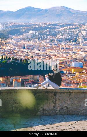 jeune femme dans des lunettes de soleil profitant de la vue sur la ville. Montagnes, port, centre-ville en arrière-plan. Paysage vertical panoramique aérien paysage urbain de Nice. Landsca Banque D'Images