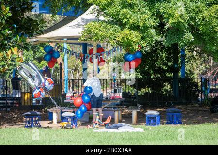 Maman se préparant pour la fête d'anniversaire des enfants dehors dans un parc à Sydney, mettant des ballons et des décorations, Australie Banque D'Images