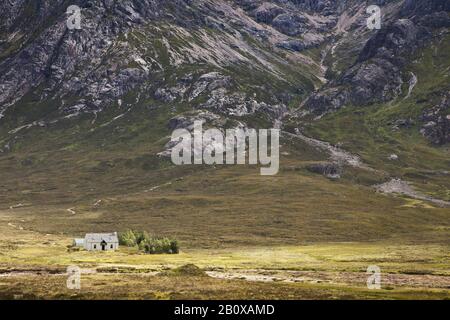 Maison solitaire en face d'une montagne à Glencoe dans les Highlands écossais, Ecosse, Grande-Bretagne, Banque D'Images