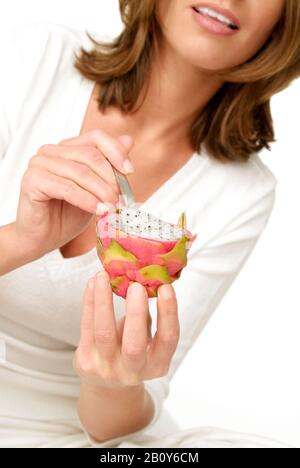 La jeune femme mange des fruits de dragon Banque D'Images