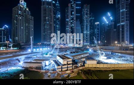 Sites de construction, projecteurs et immeubles de grande hauteur la nuit à Marina, New Dubai, Emirats Arabes Unis, Banque D'Images