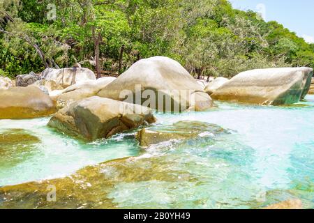 Nudey Beach, Fitzroy Island, les rochers traversent les eaux cristallines de la mer de corail avec la côte du Queensland Australie en arrière-plan. Banque D'Images