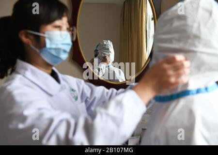 (200222) -- HEFEI, 22 février 2020 (Xinhua) -- le travailleur de la santé Sha Ximing (R) de la station de santé Yonghe dans la communauté de Changning porte une combinaison protectrice pour entrer dans la zone de quarantaine pour désinfecter et livrer le dîner à Hefei, dans la province d'Anhui, en Chine orientale, 21 février 2020. Trente-cinq membres du personnel de la division Anhui de China Construction Eighth Engineering Division Corp. Ltd., qui ont participé à la construction de l'hôpital de Leishenshan, un hôpital de fortune, destiné aux nouveaux patients atteints de pneumonie à Wuhan, sont revenus récemment à Hefei. Ils sont maintenant en quarantaine pour l'observation médicale dans un hôtel à Hefei. Chacun des Banque D'Images