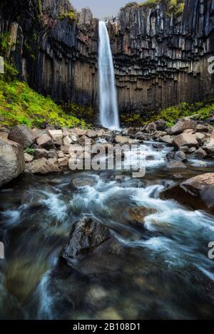 Cascade de Svartifoss en automne avec cours d'eau en exposition à long terme, parc national de Skaftafell, Islande Banque D'Images