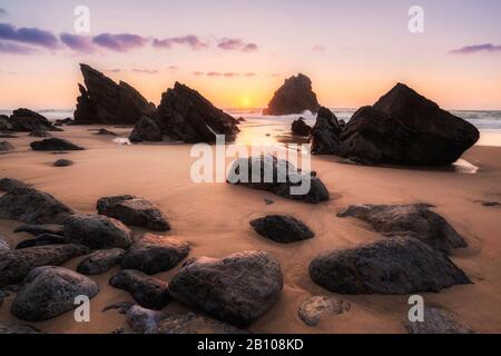 Les rochers à marée basse sur la plage au coucher du soleil, Praia da Adraga, Sintra, Portugal Banque D'Images