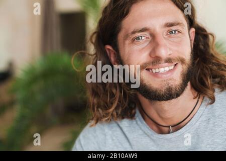 Image d'un jeune homme heureux et joyeux à l'intérieur en posant à la maison. Banque D'Images