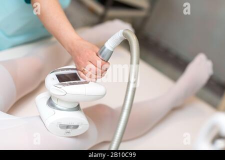 Jeune femme belle et procédure de massage GPL dans la clinique de spa. Processus d'appareil de massage de drainage lymphatique GPL. Banque D'Images