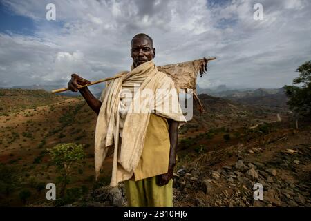 Un homme tigroyan tient un bâton avec un morceau séché de peau de chèvre, les montagnes Simien, Ethiopie Banque D'Images