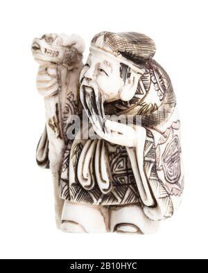 ancien netsuke japonais - vieil homme avec du personnel sculpté à partir d'ivoire isolé sur fond blanc Banque D'Images