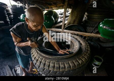 Recyclage, l'homme construit des meubles à partir de vieux pneus de camion, South Luzon, Philippines Banque D'Images