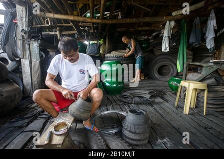 Recyclage, les hommes construise des meubles à partir de vieux pneus de camions, South Luzon, Philippines Banque D'Images