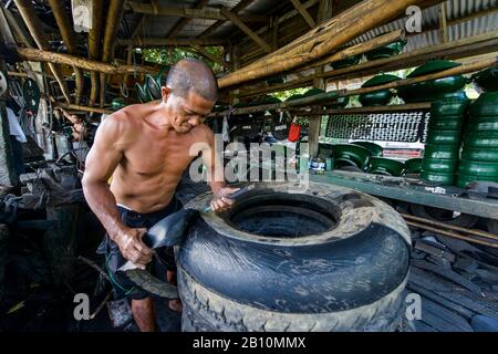 Recyclage, l'homme construit des meubles à partir de vieux pneus de camion, South Luzon, Philippines Banque D'Images