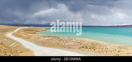 Cyclisme sur le lac de Ngoguoring sur le plateau tibétain avant une tempête, province de Qinghai, Chine Banque D'Images