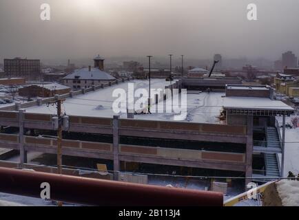 Syracuse, New York, États-Unis. 20 Février 2020. Vue sur le garage de stationnement en construction pour un hôpital avec neige tombant au lever du soleil sur le nord de S Banque D'Images