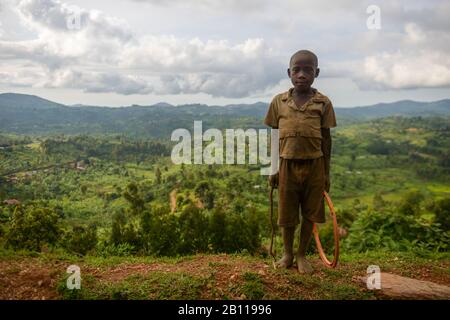 L'enfant joue avec un hoop dans les montagnes de l'Ouganda occidental, en Afrique Banque D'Images